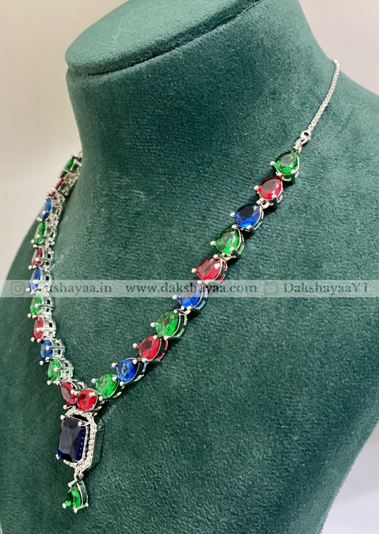 Multicolored gemstone necklace on a green mannequin