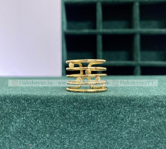 Gold ring on a green textured surface with a blurred background