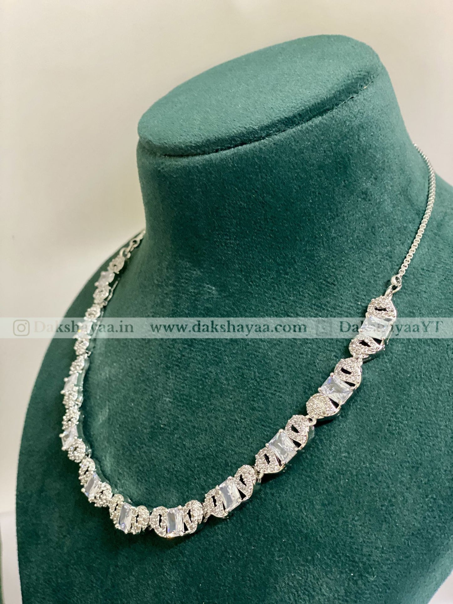 Silver necklace on a green velvet mannequin bust