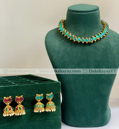 Jewelry set with necklace and earrings on a green mannequin and box.