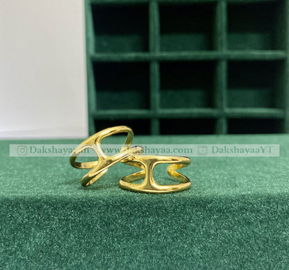 Two gold rings on a green surface with a green jewelry box in the background.