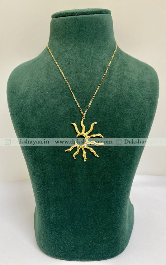 Gold necklace with a sun pendant on a green mannequin bust.