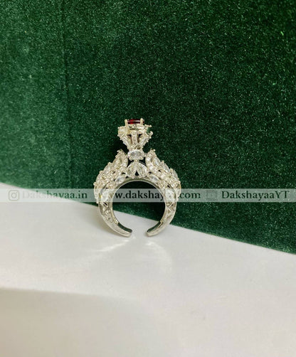 Silver ring with gemstone on a green and white background