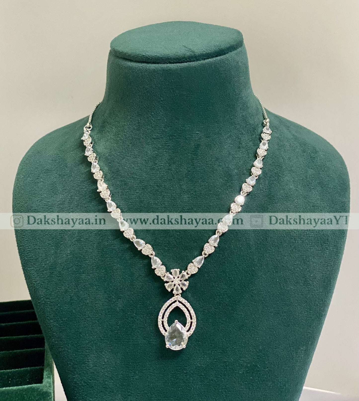 Necklace on a green mannequin with visible brand watermark