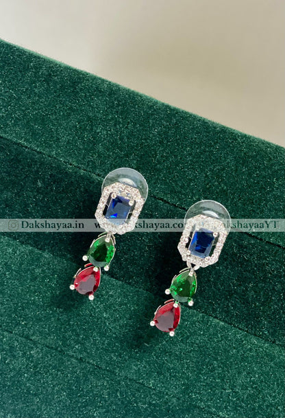 Pair of earrings with gemstones on a green surface