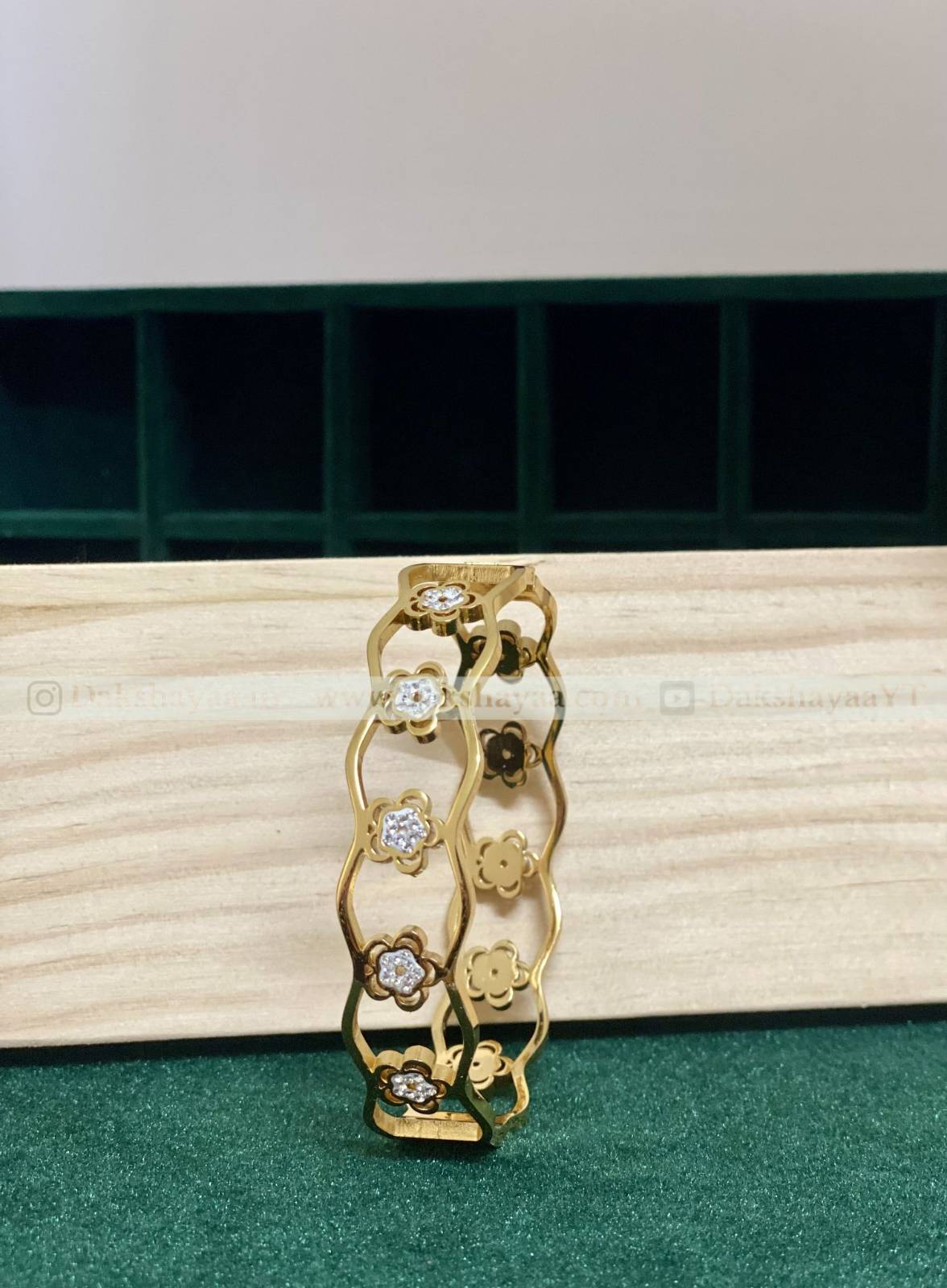 Gold kada with diamond accents on a wooden surface