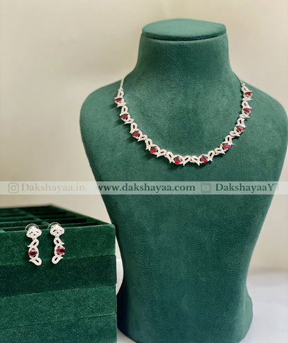 Jewelry set with necklace and earrings on a green mannequin and box, brand 'Dakshayaa' visible.
