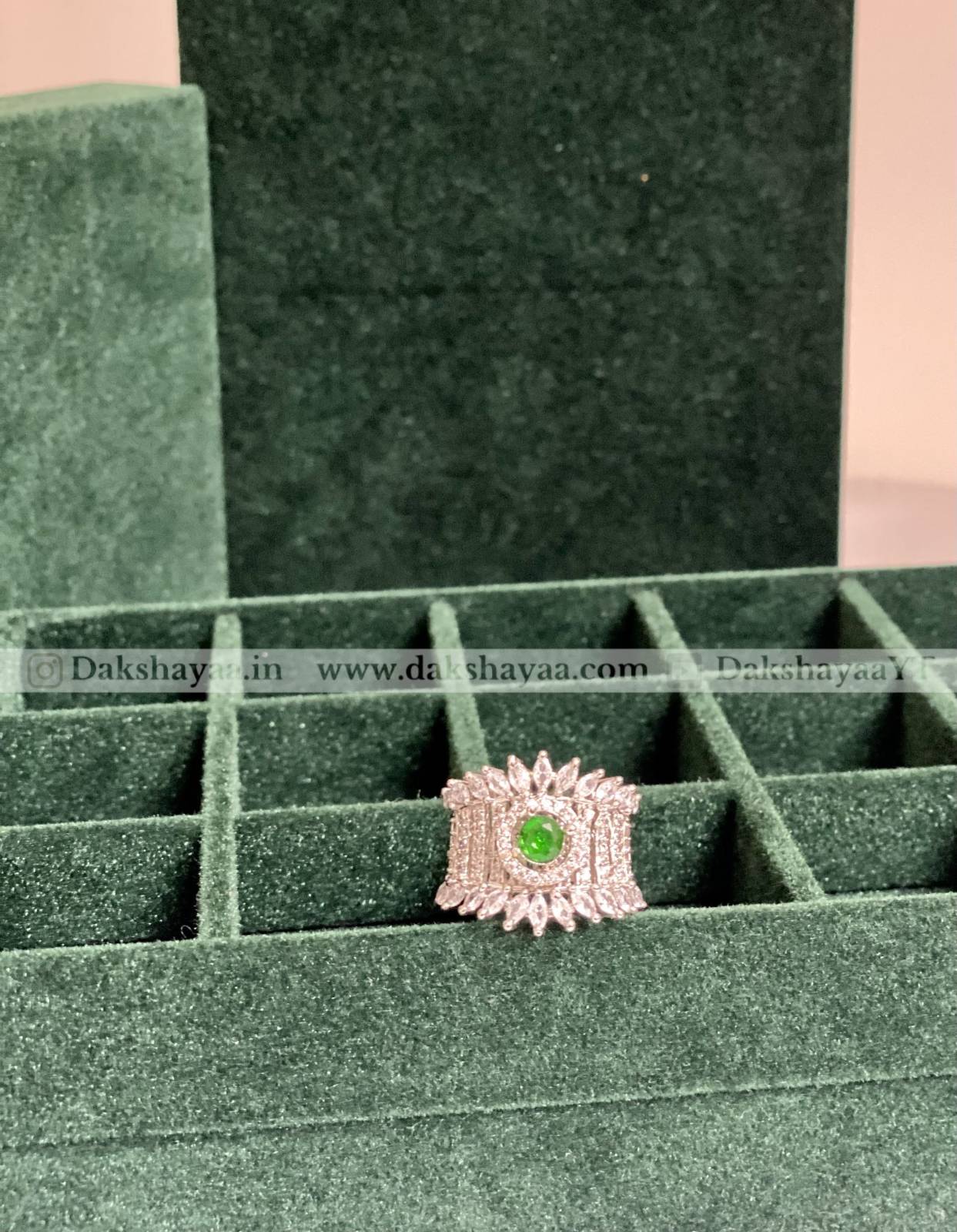 Ring with a green gemstone in a green jewelry box