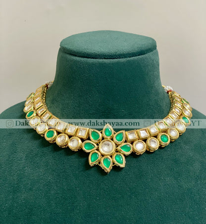 Decorative necklace with green and white stones on a green velvet stand