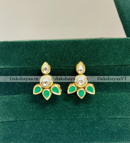 Gold and green earrings on a green velvet background