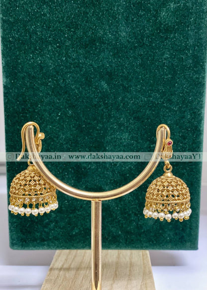 Gold earrings with pearl details on a green stand