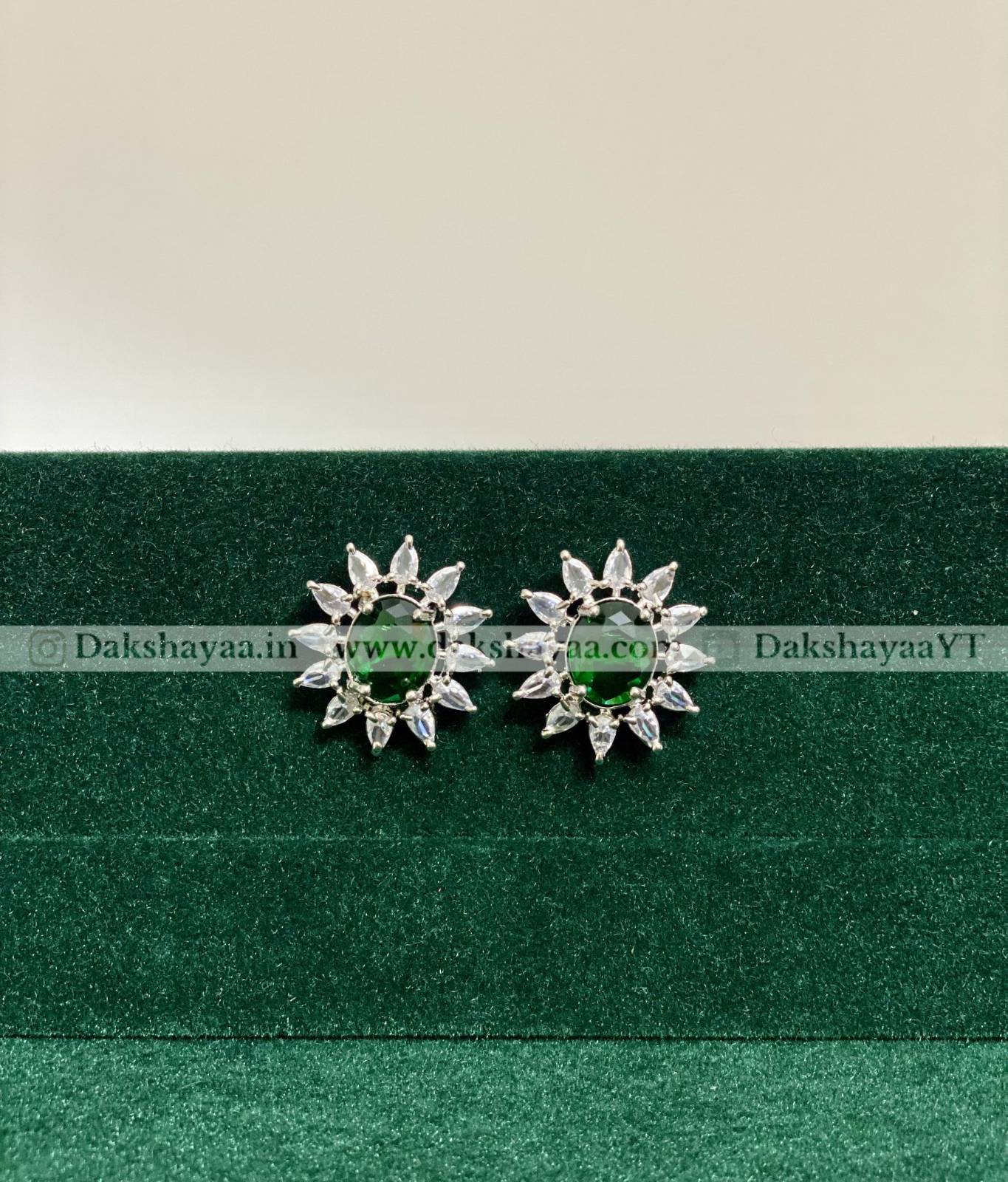 Pair of green silver earrings on a green background