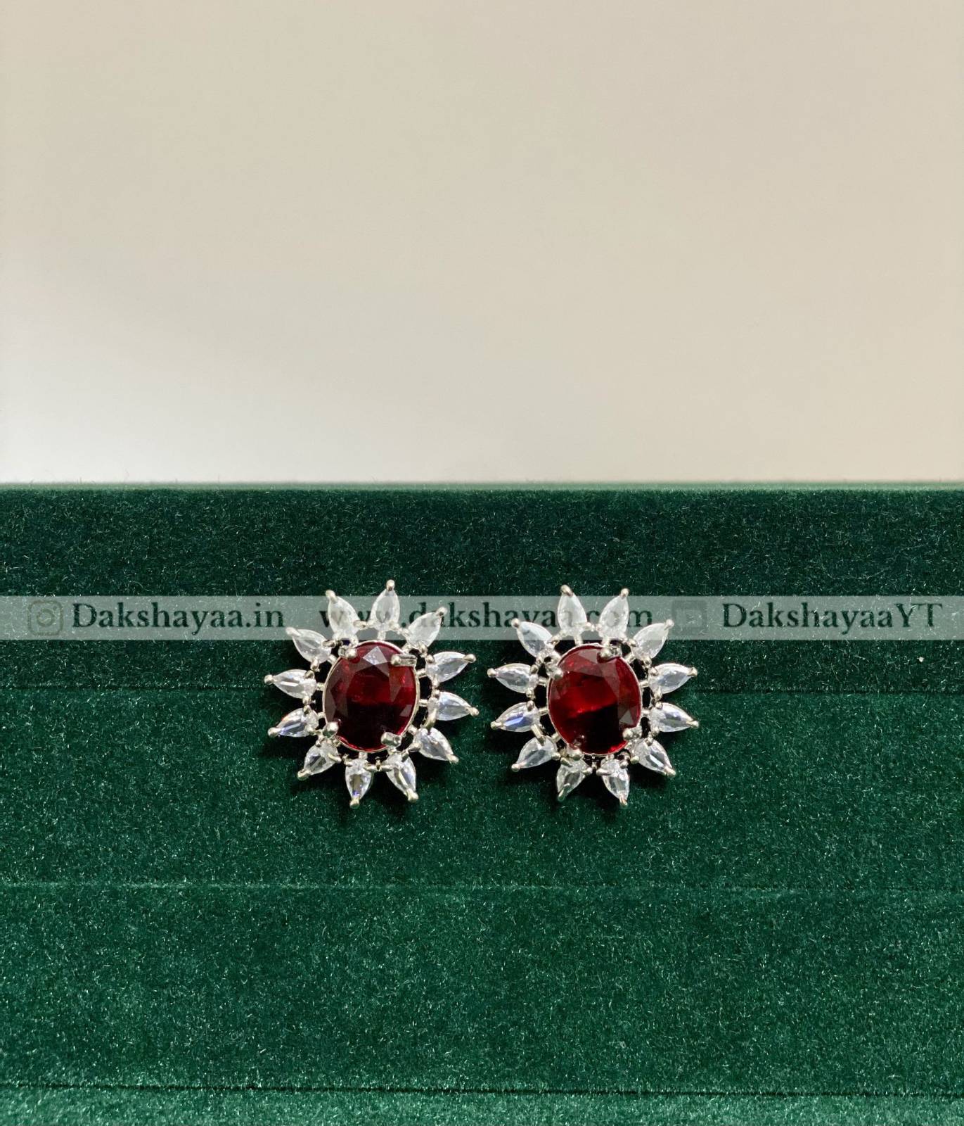 Pair of RED silver earrings with red gemstones on a green background