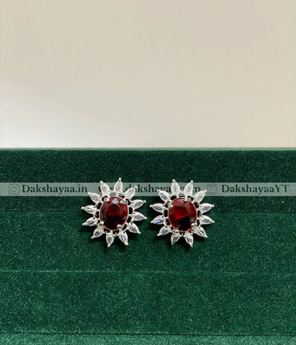 Pair of RED silver earrings with red gemstones on a green background