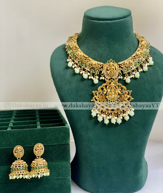 mint green Gold necklace and earrings on a green mannequin with a green box in the background