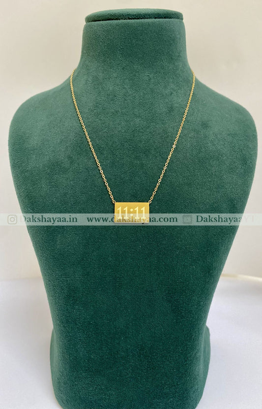Gold necklace on a green mannequin bust with visible brand name.