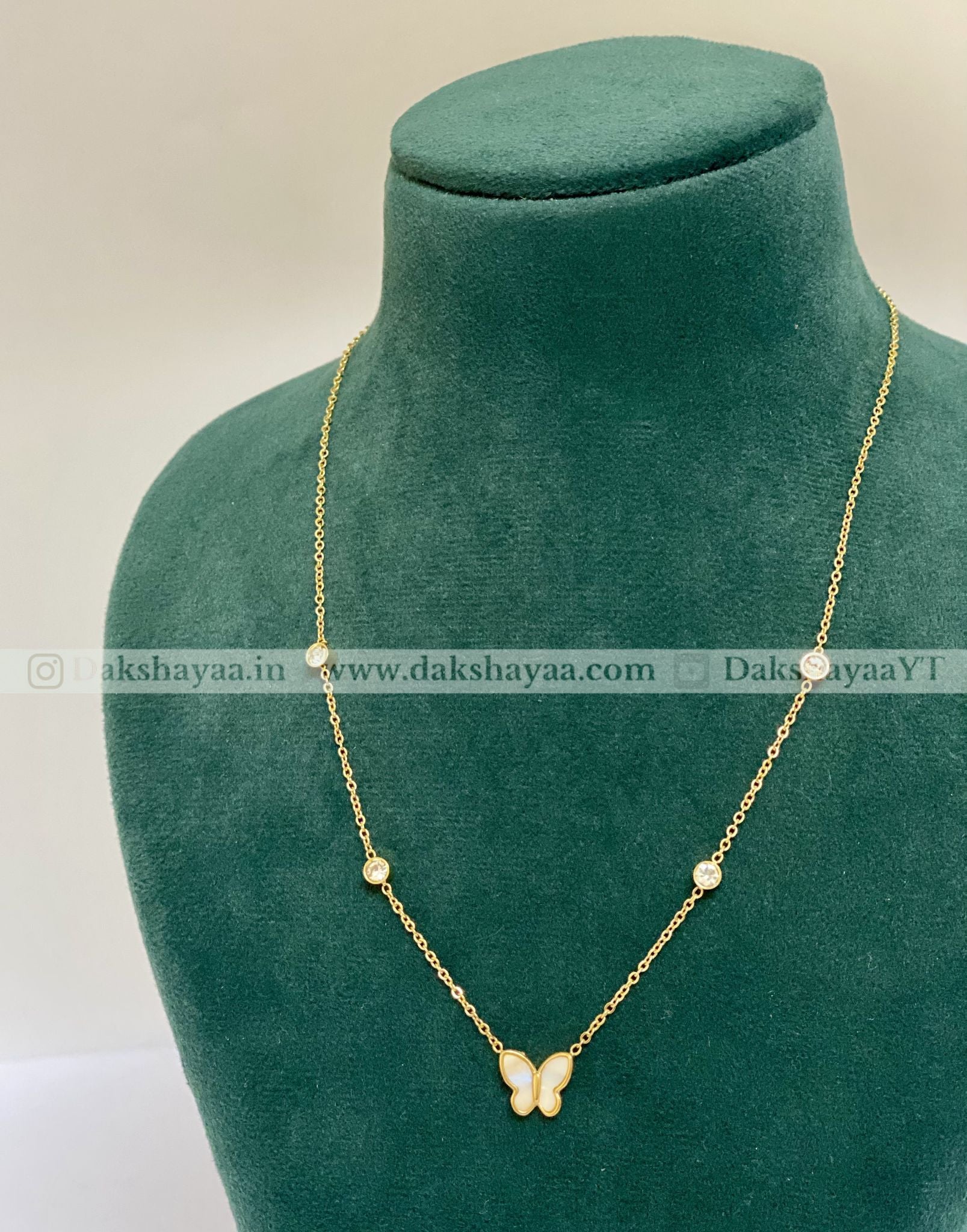 Gold necklace with heart-shaped pendants on a green velvet anti tarnish