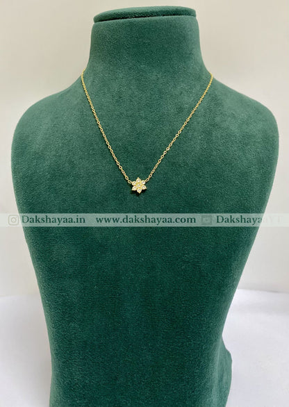 Gold necklace with a star pendant on a green mannequin bust, brand 'Dakshayaa' visible.