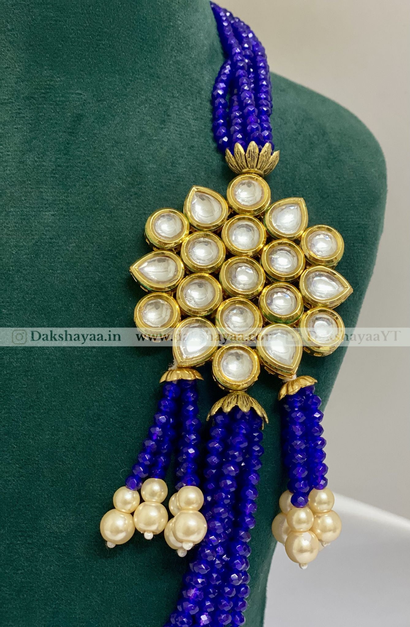 Decorative pendant with blue and gold elements on a green cushion