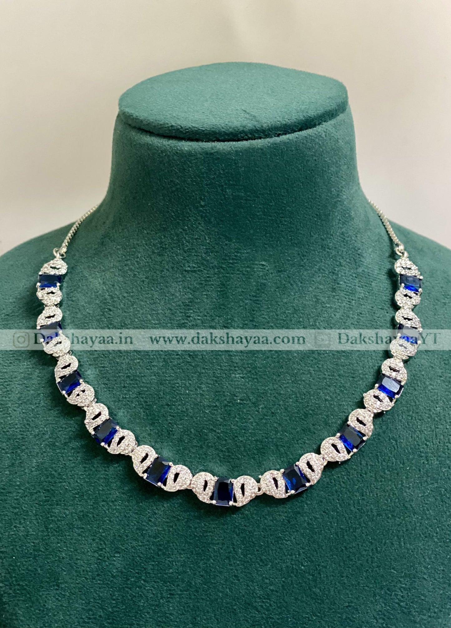 Necklace with blue and silver beads on a green mannequin