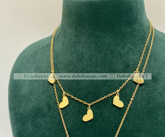 Gold necklace with heart pendants on a green mannequin