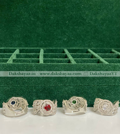 Four silver rings with gemstones on a green velvet background