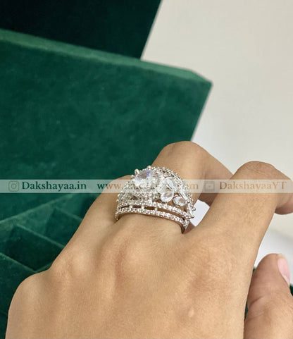 Three silver rings on a finger with a green box in the background