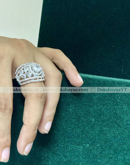 Hand wearing a decorative ring on a green fabric background