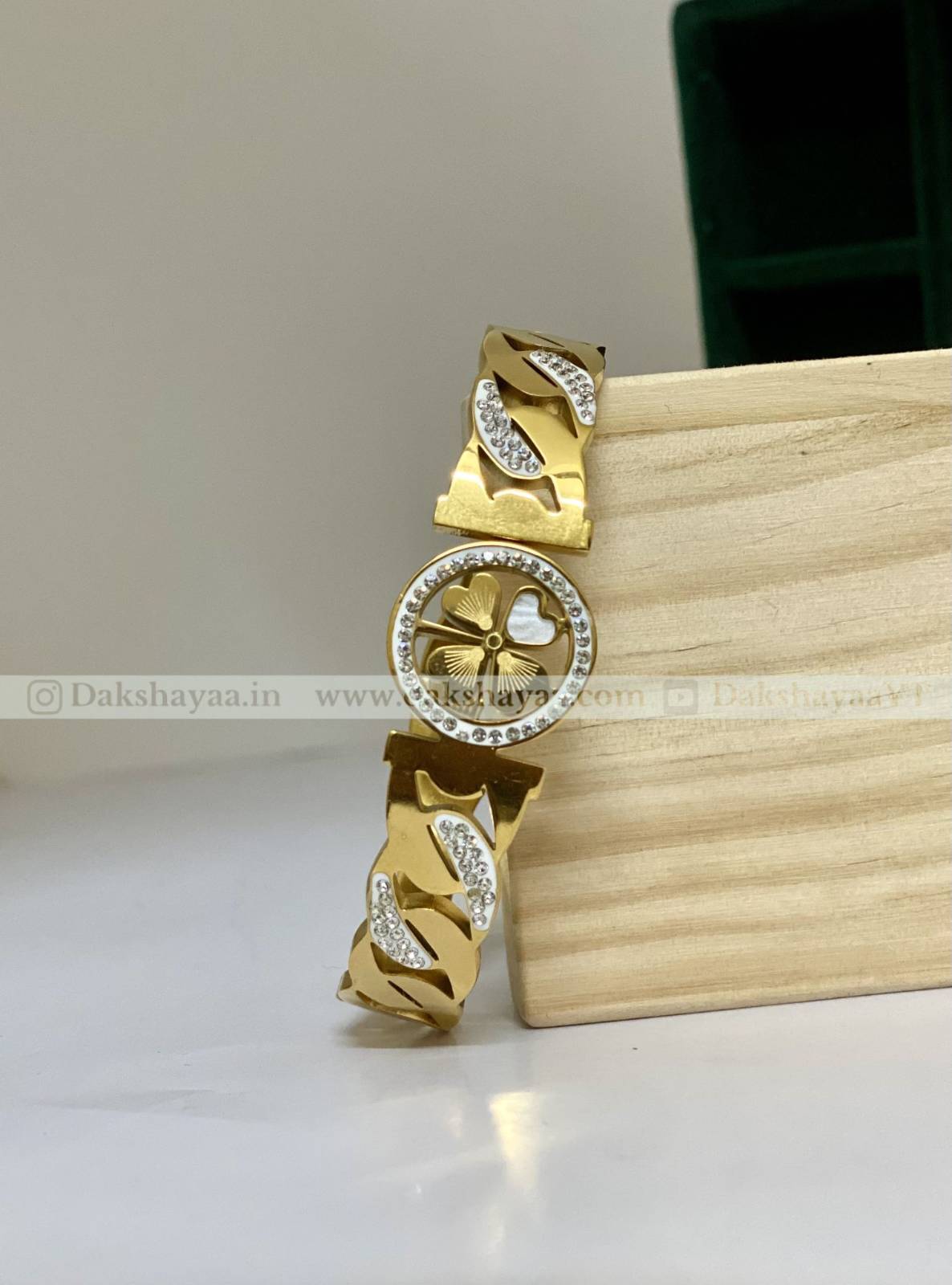 Gold bracelet with diamond accents on a wooden block