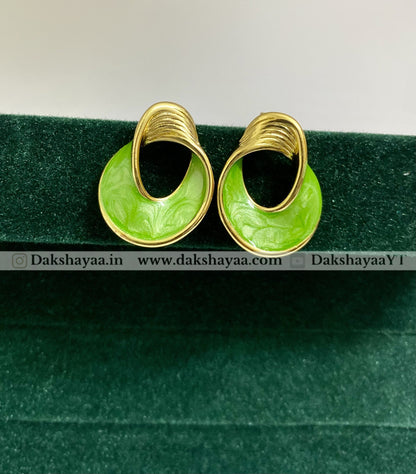Gold hoop earrings with green circular centers on a green background