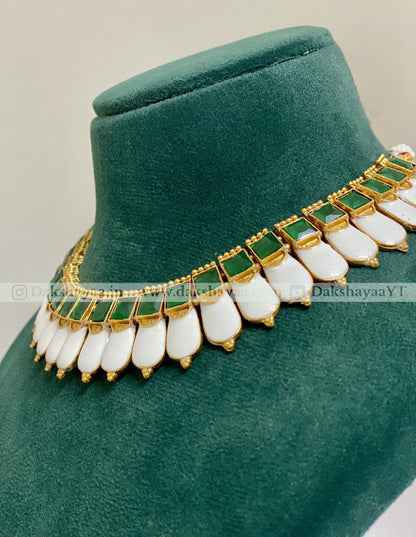 Jewelry set with green and white stones on a green velvet stand