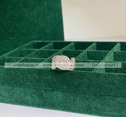 Silver ring on a green jewelry box with visible branding.