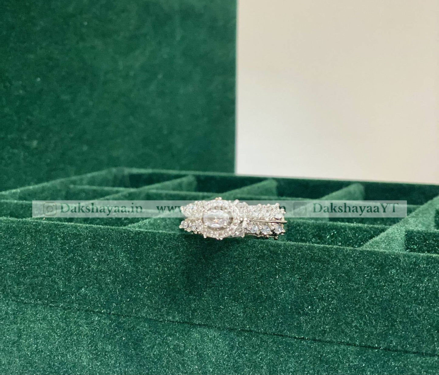 Silver ring with a green velvet box