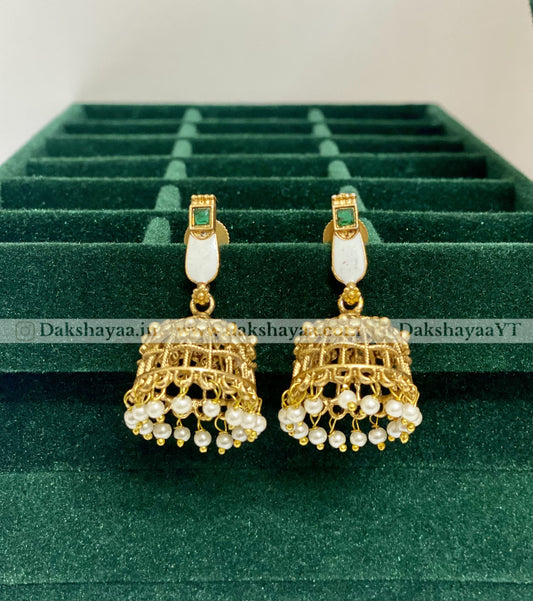 Gold and pearl earrings on a green velvet display box